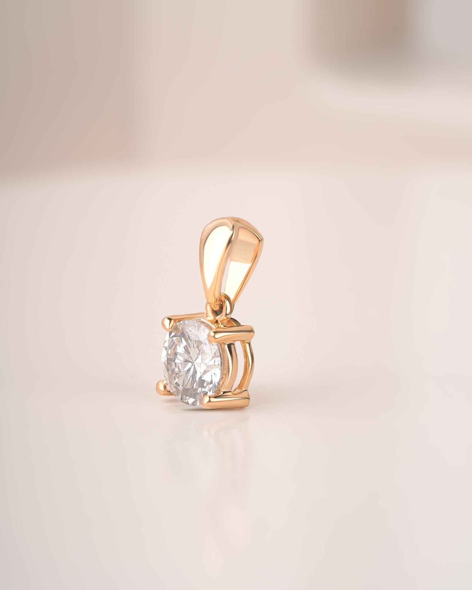 Side view of round cut lab grown diamond solitaire pendant on a white background.