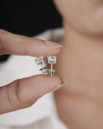 Hand holding silver studs in white gold.