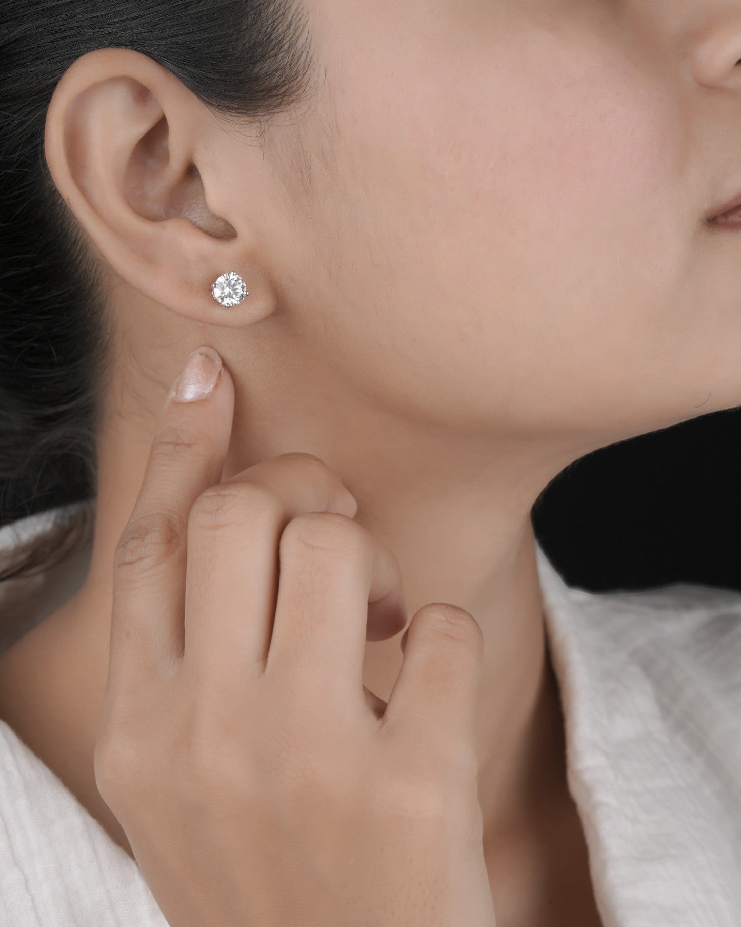 Person wearing silver studs in white gold.