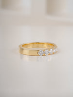seven stone diamond ring in yellow gold on white background
