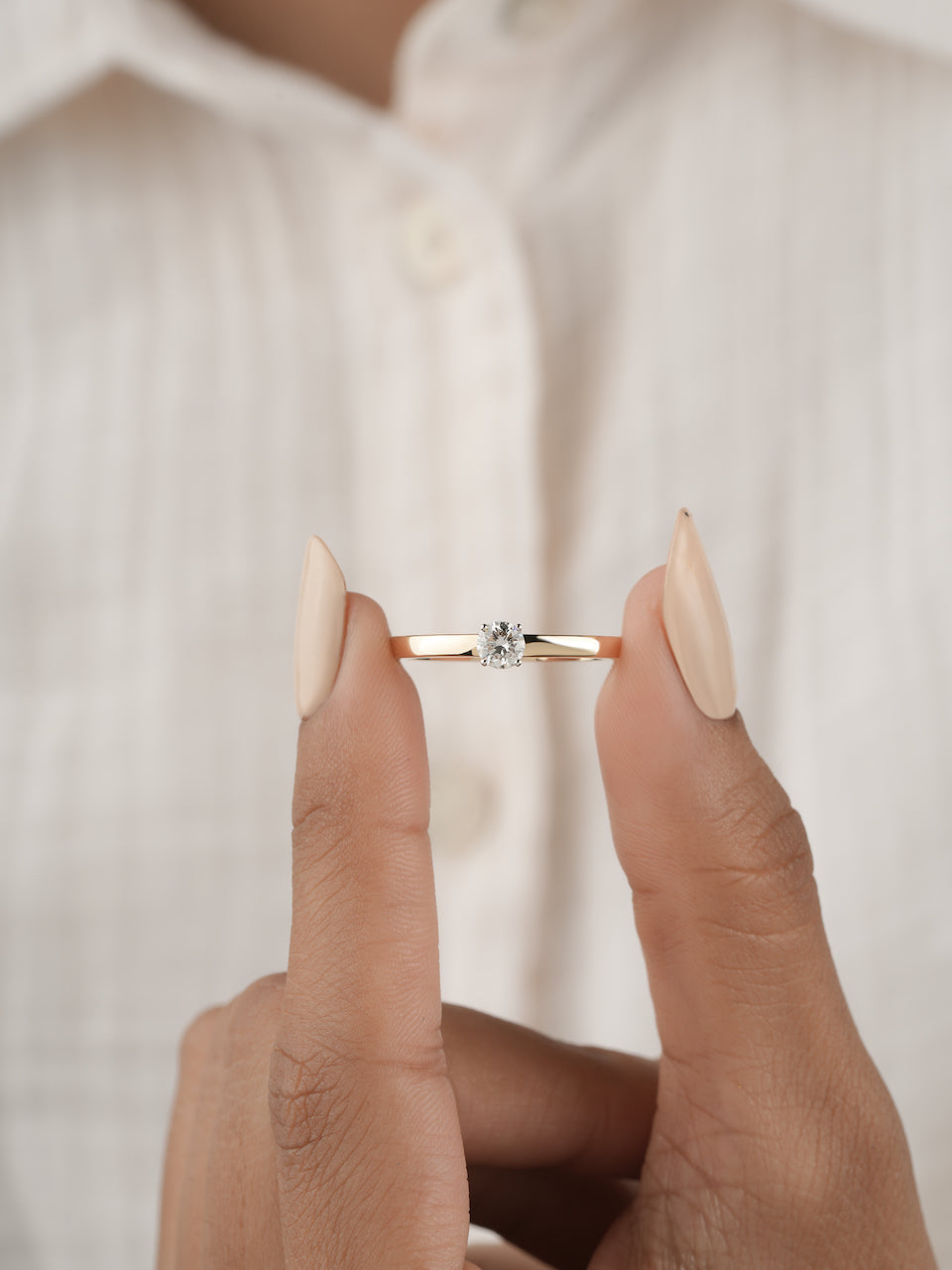 0.30ct round brilliant diamond solitaire engagement ring in yellow gold, worn on hand