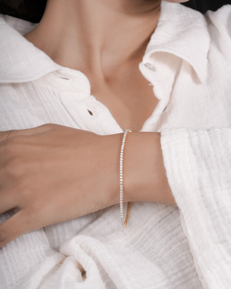 Close-up of a person wearing a pearl bracelet on a white background