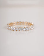 Gold ring with clear gemstones on a light gray background