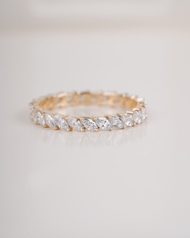 Gold ring with clear gemstones on a light gray background