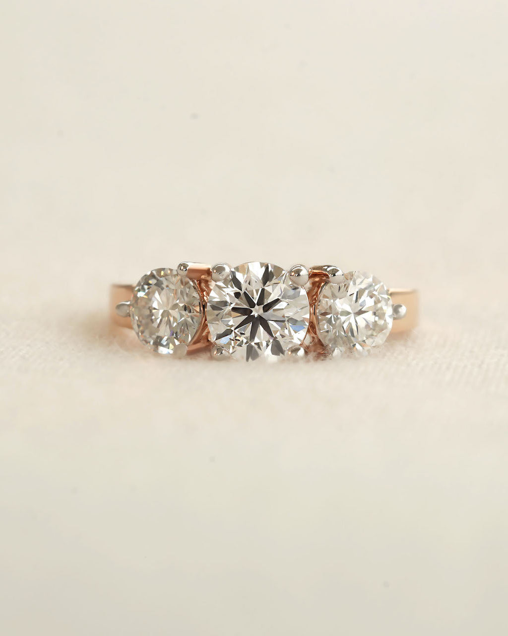 Round Cut Three-Stone Engagement Ring with Four-Prong Basket Setting