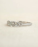 Three stone round cut lab grown diamond ring on a white background.