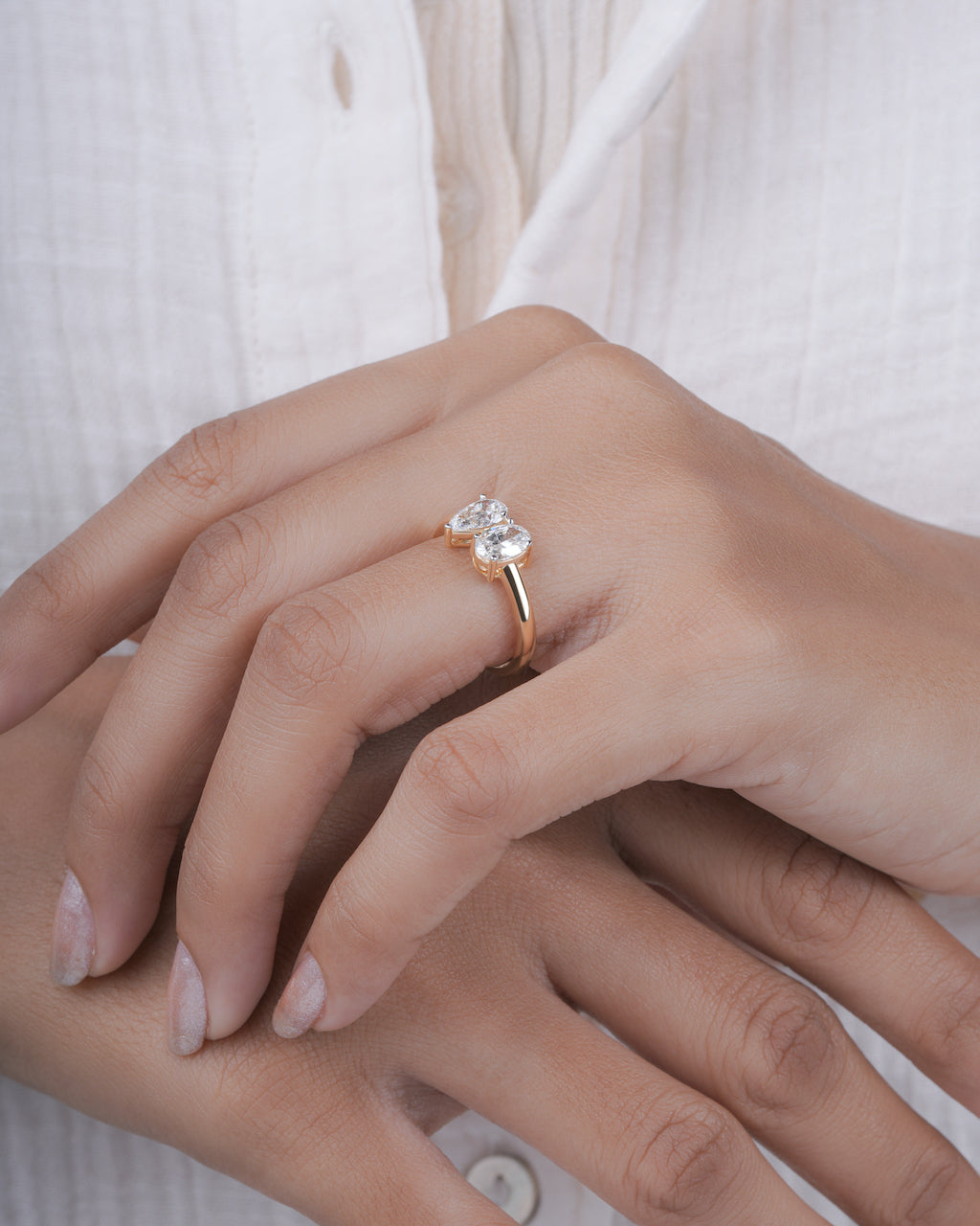 Close-up of a hand wearing a diamond ring on a blurred background