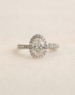 Close up shot of white gold oval halo engagement ring.