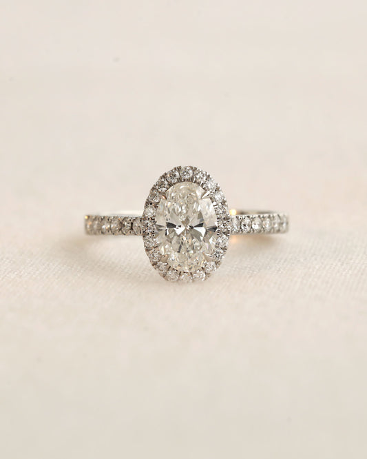 Close up shot of white gold oval halo engagement ring.