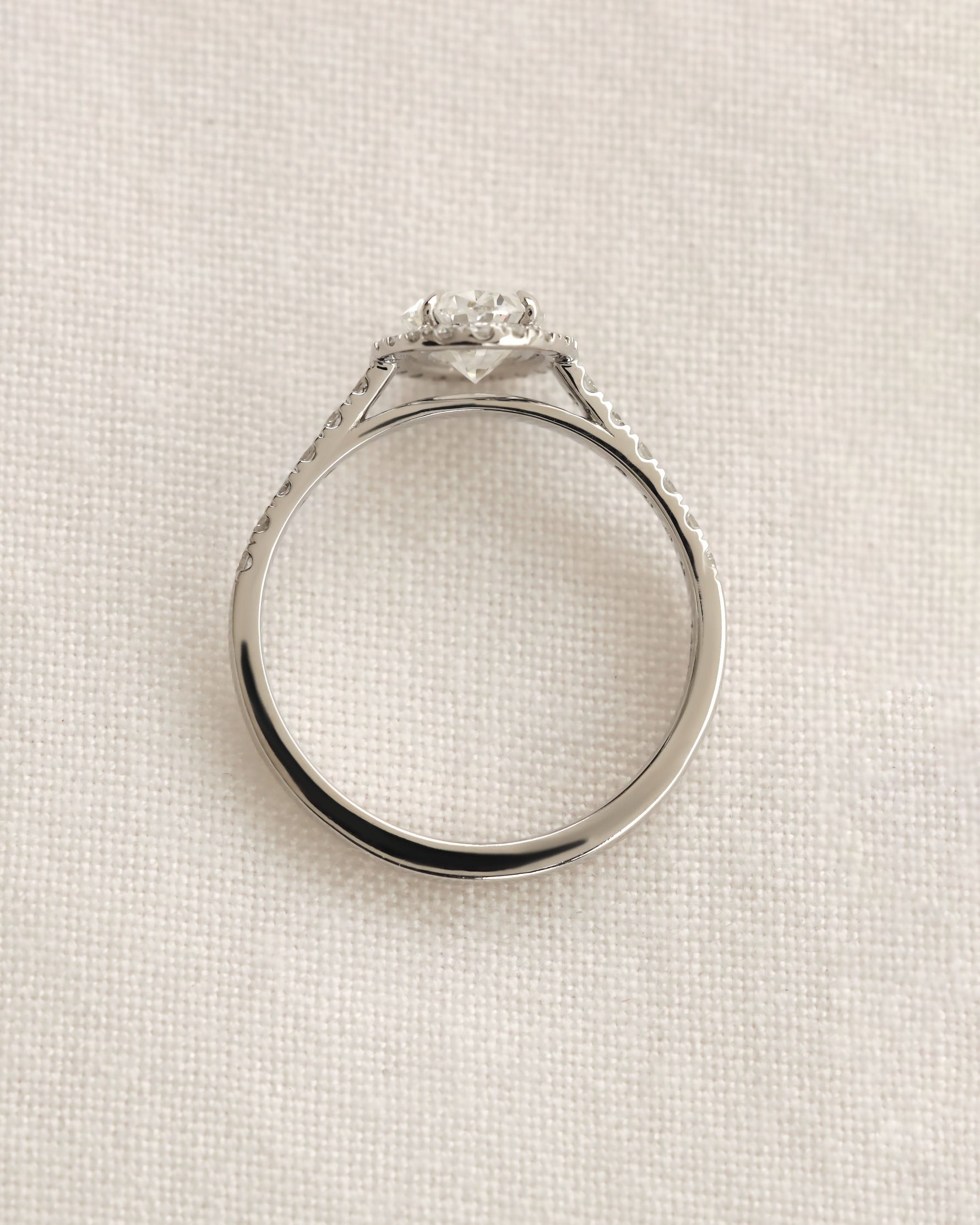 Close up shot of white gold oval halo engagement ring. 