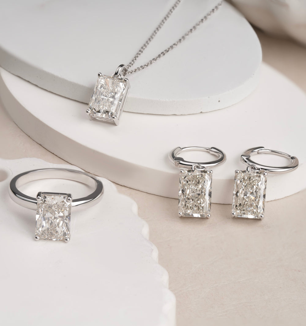 LAGANI emerald-cut diamond ring, pendant and earrings displayed together